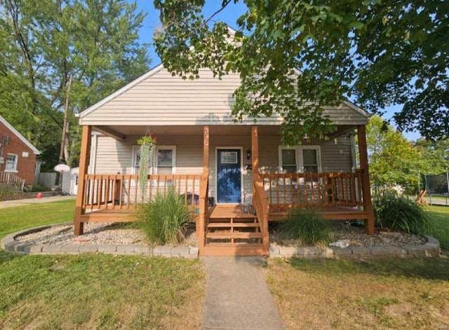 bungalow with covered porch and a front yard