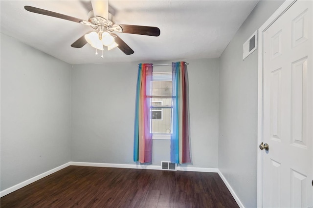 empty room with visible vents, ceiling fan, baseboards, and wood finished floors