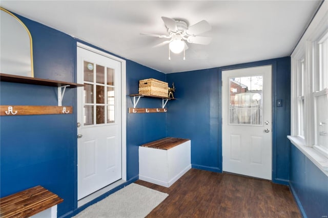 doorway featuring baseboards, wood finished floors, and a ceiling fan