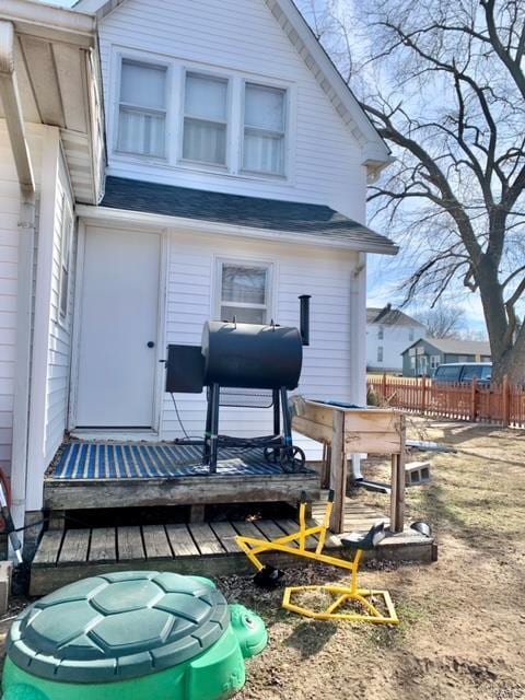 rear view of property with fence and heating fuel