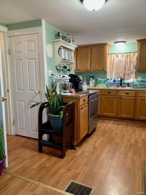 kitchen featuring brown cabinets, visible vents, and light wood finished floors