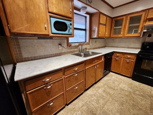 kitchen featuring black appliances, brown cabinetry, a sink, and light countertops