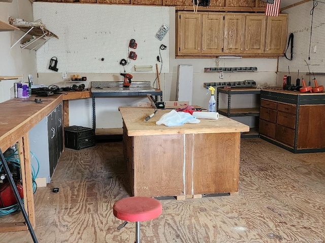 kitchen with light countertops, a center island, and brown cabinets