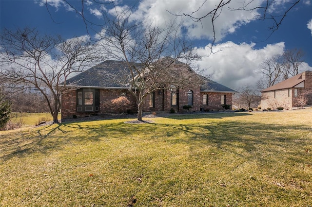 view of front of house featuring brick siding and a front yard