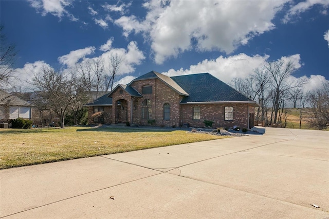 view of front facade featuring brick siding and a front yard