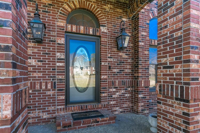 doorway to property featuring brick siding