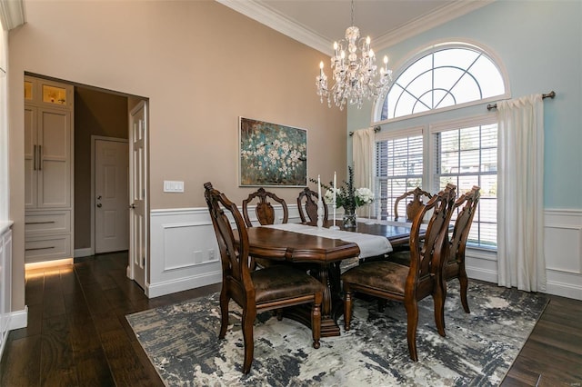 dining area with dark wood-style floors, ornamental molding, and a wainscoted wall