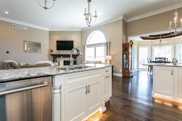 kitchen featuring visible vents, an inviting chandelier, open floor plan, a sink, and dishwasher