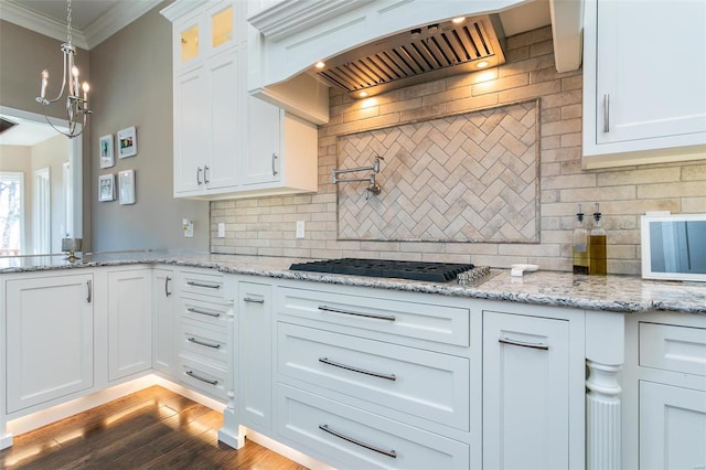 kitchen featuring gas cooktop, white cabinets, crown molding, and custom exhaust hood