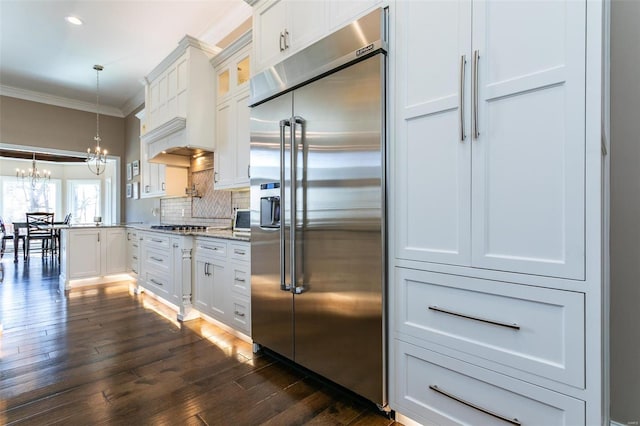 kitchen featuring a notable chandelier, appliances with stainless steel finishes, backsplash, glass insert cabinets, and crown molding