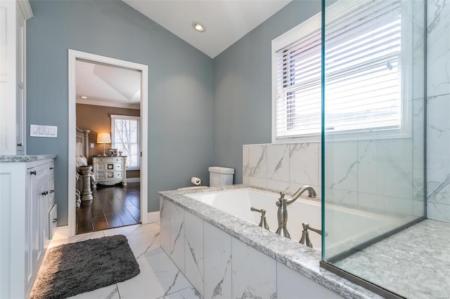 full bathroom featuring a garden tub, baseboards, vaulted ceiling, marble finish floor, and ornamental molding