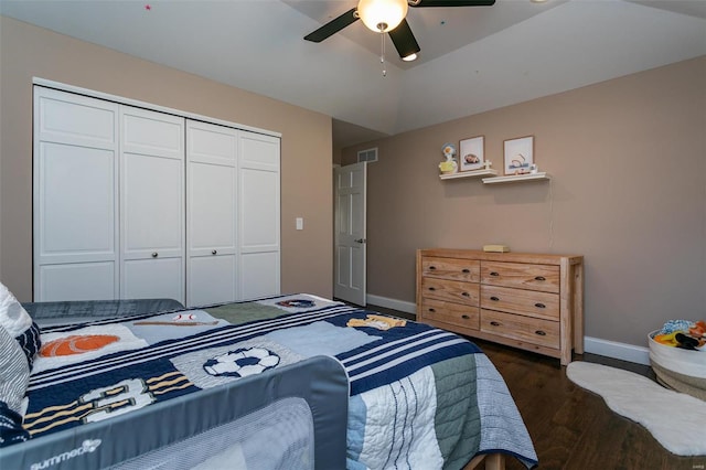 bedroom featuring dark wood finished floors, lofted ceiling, a closet, visible vents, and baseboards