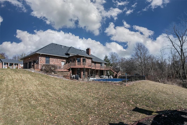 back of house featuring a wooden deck, a patio, stairway, a yard, and brick siding