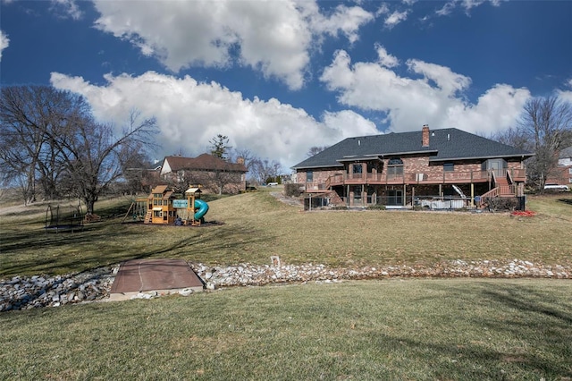 view of yard with playground community and a wooden deck