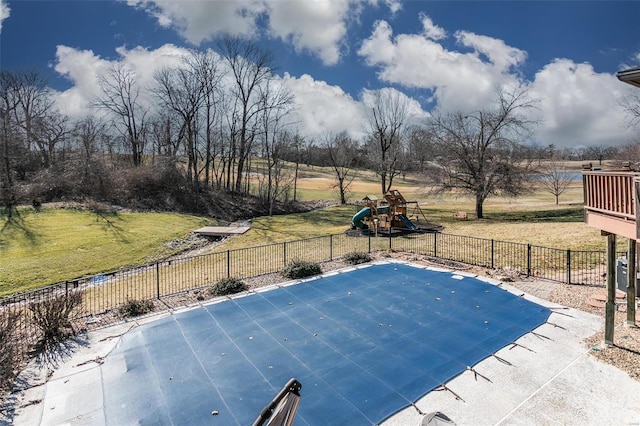 view of pool featuring a lawn, a playground, and fence