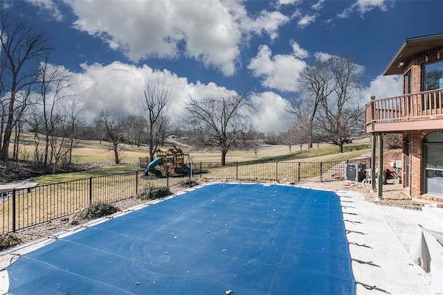 view of pool featuring a playground and fence