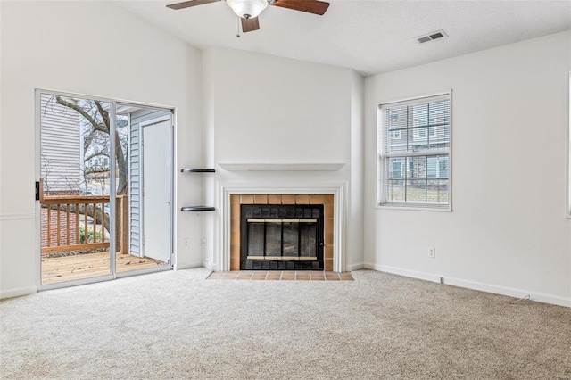 unfurnished living room with carpet floors, a fireplace, visible vents, and baseboards