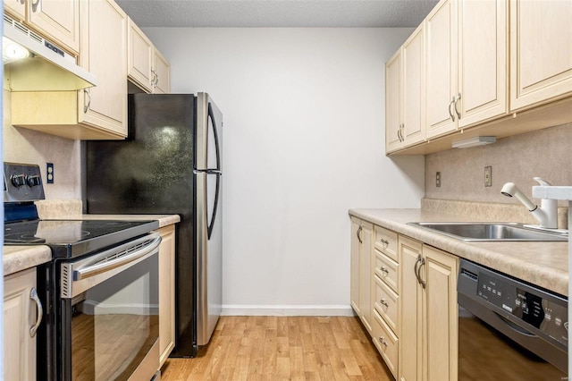 kitchen featuring light wood finished floors, black dishwasher, under cabinet range hood, stainless steel range with electric stovetop, and a sink