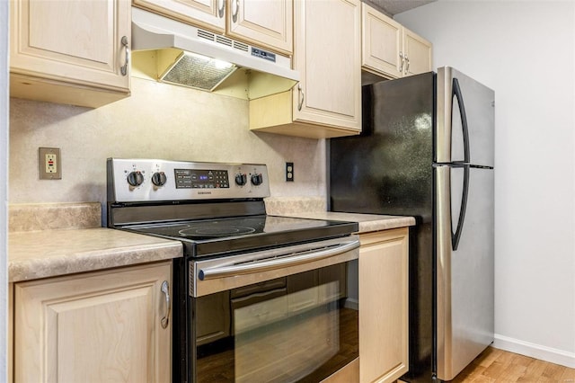 kitchen with stainless steel appliances, light countertops, light wood-style floors, under cabinet range hood, and baseboards