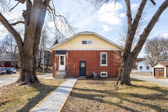 bungalow-style house featuring brick siding and central air condition unit