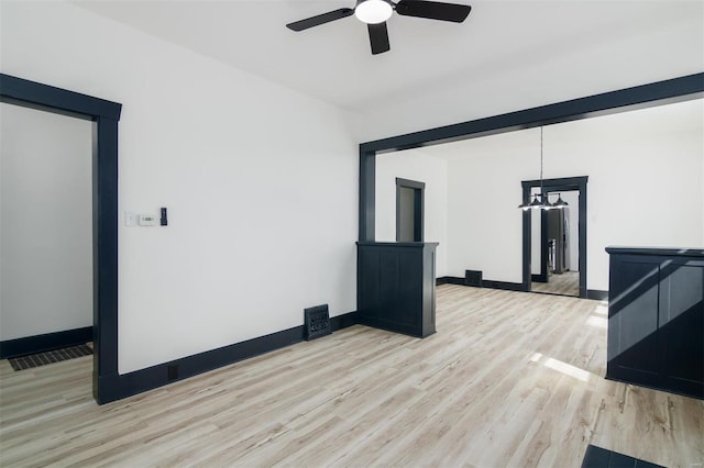 interior space with light wood-type flooring, visible vents, ceiling fan, and baseboards