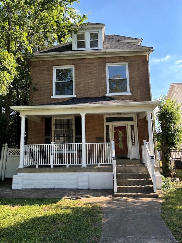 traditional style home with covered porch and brick siding