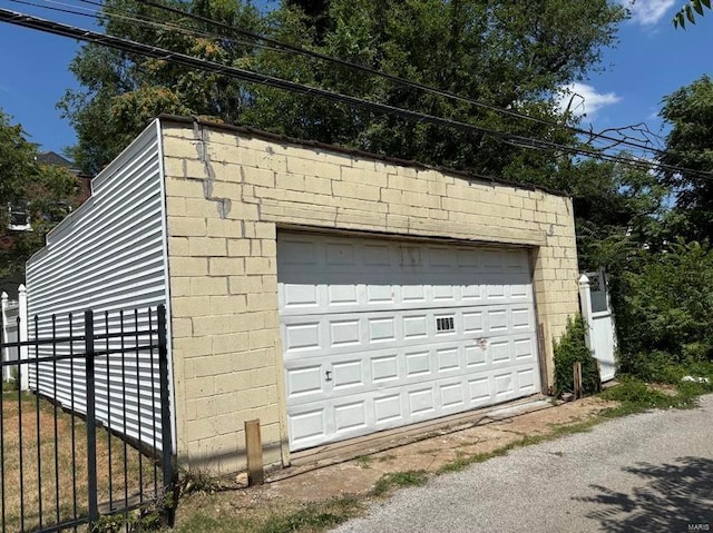 detached garage featuring fence