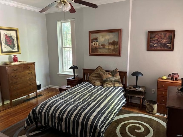 bedroom with ceiling fan, ornamental molding, wood finished floors, and baseboards