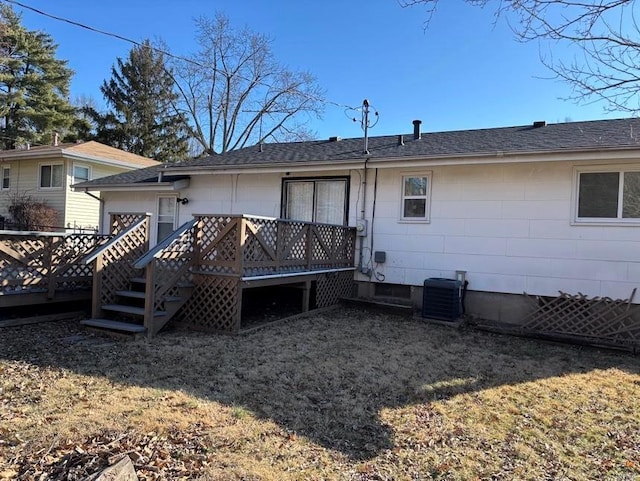 rear view of house featuring a deck, cooling unit, and roof with shingles