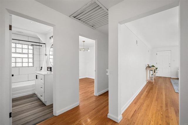 hall featuring light wood-style floors and baseboards