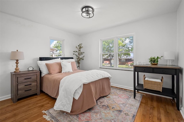 bedroom with baseboards and wood finished floors