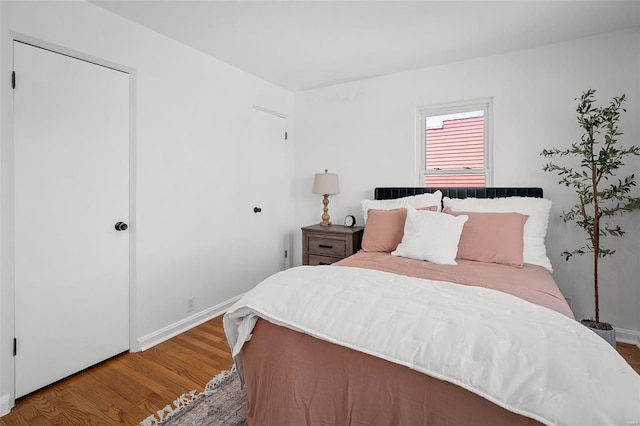 bedroom with baseboards and wood finished floors