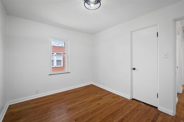 empty room featuring baseboards and wood finished floors