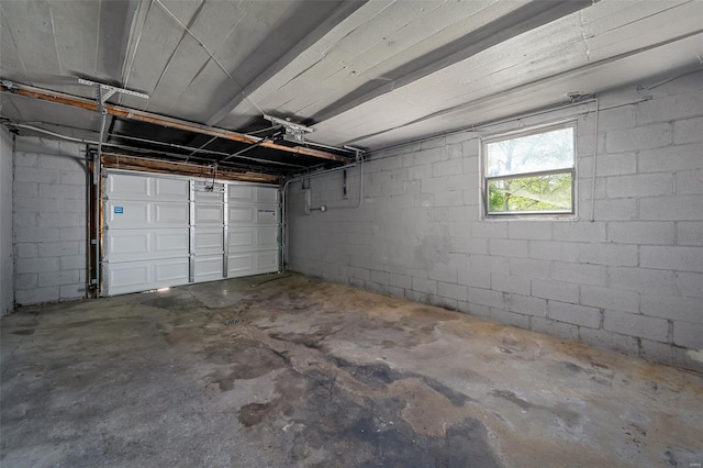 garage featuring a garage door opener and concrete block wall