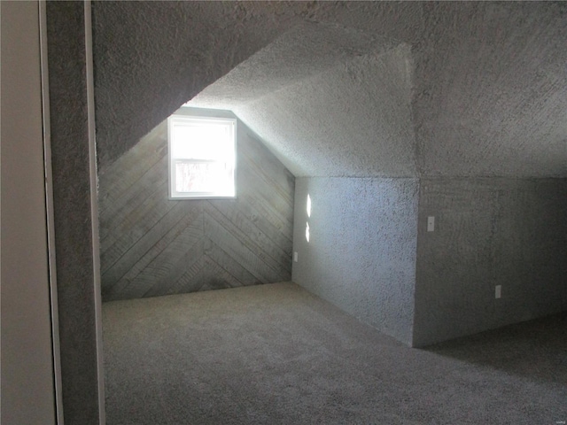 bonus room featuring carpet flooring, a textured ceiling, and vaulted ceiling