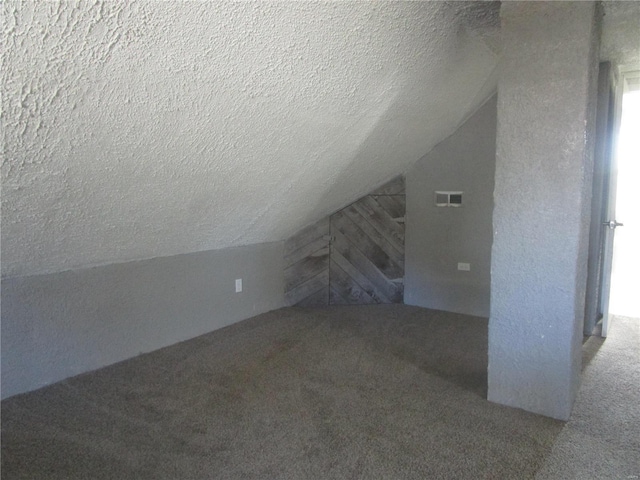 additional living space featuring lofted ceiling, carpet flooring, visible vents, and a textured ceiling