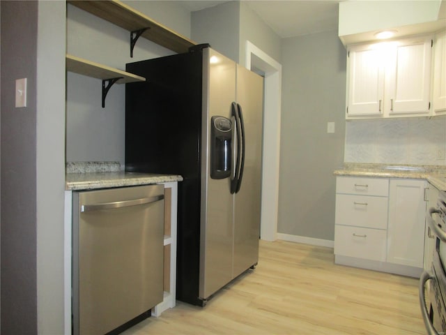 kitchen featuring baseboards, light wood-type flooring, stainless steel appliances, white cabinetry, and open shelves