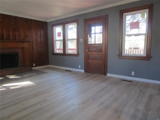 unfurnished living room featuring visible vents, a fireplace, wood finished floors, and crown molding