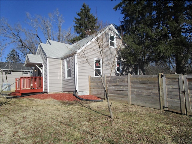 back of house with a lawn, a deck, and fence