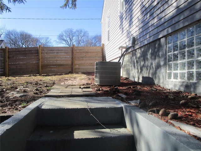 exterior space with central AC unit and fence