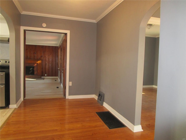 corridor featuring arched walkways, visible vents, crown molding, and wood finished floors