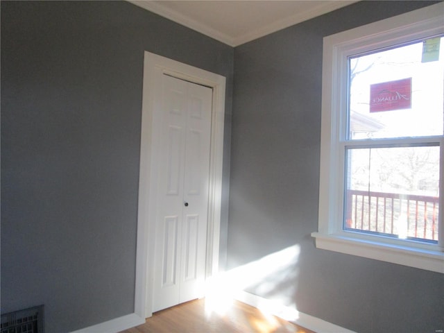 unfurnished room with baseboards, wood finished floors, and ornamental molding