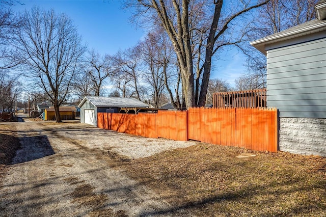 view of yard with a garage, fence, and an outbuilding