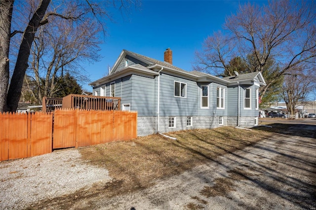 view of side of property featuring fence and a chimney