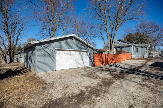 detached garage featuring fence