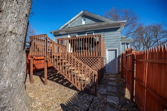 back of house featuring fence, stairway, and a wooden deck