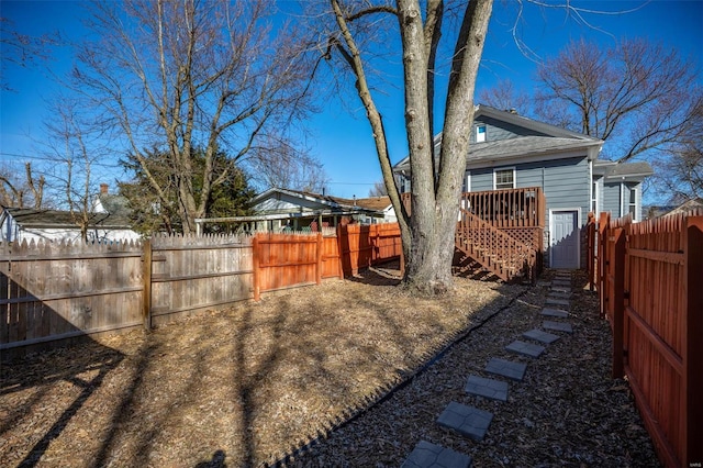 view of yard with fence private yard, a deck, and stairs