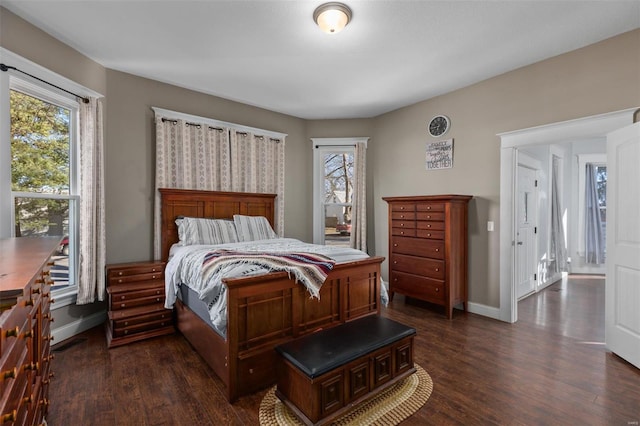 bedroom with multiple windows, baseboards, and dark wood-style flooring