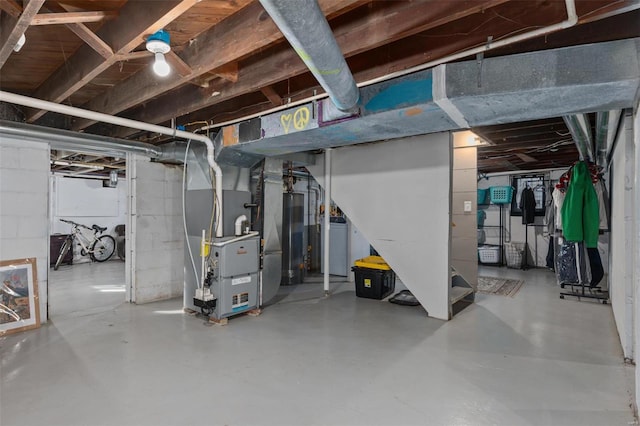 unfinished basement featuring washer / clothes dryer, gas water heater, and heating unit