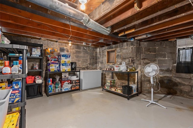 unfinished basement with fridge